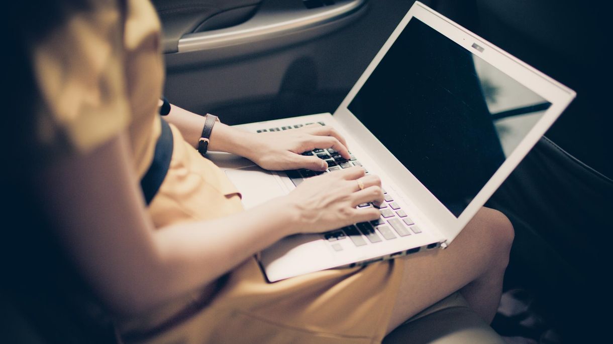 A woman in the back of our taxi on a laptop